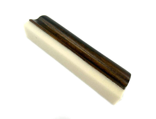 A white and brown sponge on a cherry wood Beard Bar, designed to effortlessly capture stray beard hairs in one swipe, leaving your bathroom clean and tidy.
