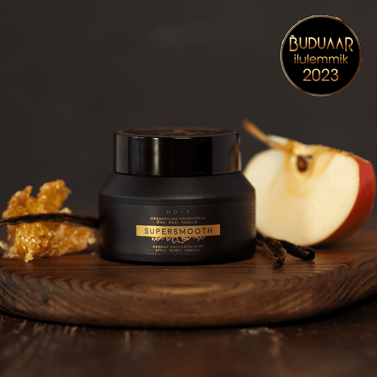 A jar of Organic Face Scrub with apple water and olive stone powder for gentle exfoliation and deep moisturization.