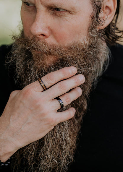A close-up of a man's hand wearing the Men's ring Kahoy, made of high-quality ceramics and natural veneer. Lightweight and durable, this contemporary ring is perfect for everyday wear or as a unique gift for a discerning gentleman.