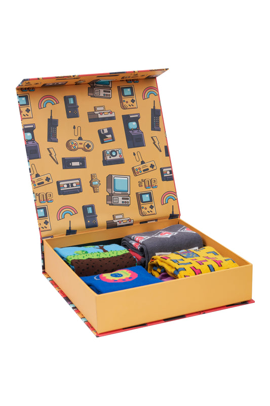 A box full of socks from the 90s Games collection, featuring iconic game graphics. High-quality cotton blend materials from Turkey.Alt Text: "90s Games Socks Box filled with soft and durable cotton blend socks featuring iconic game graphics from Men In Style."