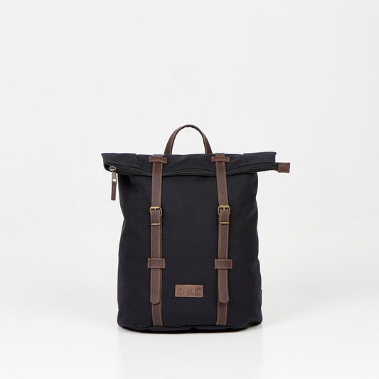 A black waterproof backpack with brown leather straps, perfect for urban adventures and daily commutes. Spacious 12L capacity, padded laptop compartment, and multiple pockets for organized storage. Handcrafted in Europe for quality and reliability.