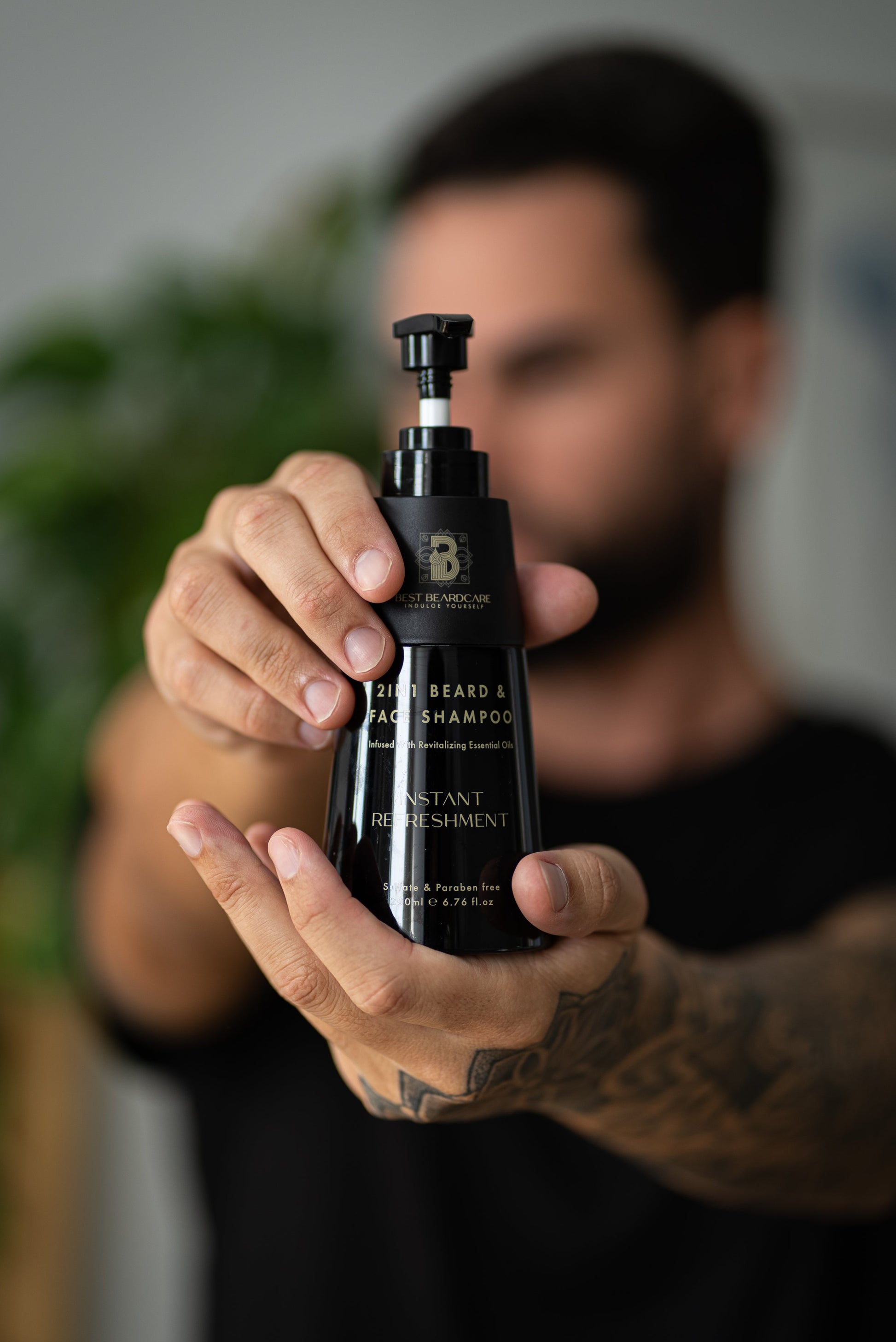 A person holding a black bottle of 2in1 Beard And Face Shampoo, providing deep cleansing and nourishment for your beard and facial skin.