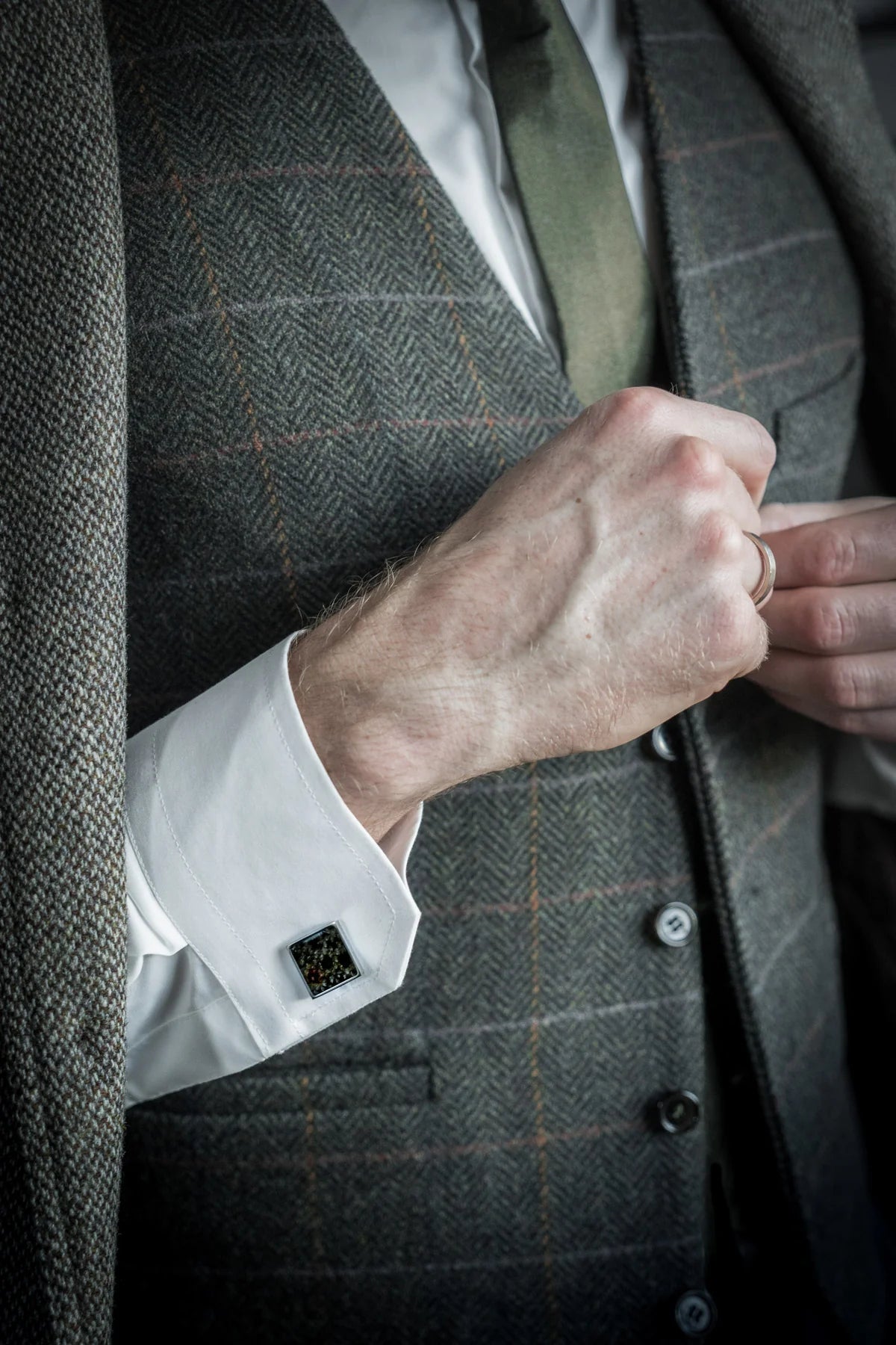 Cufflinks - Square - Dark Trout Leather displayed on a suited man's wrist, showcasing unique fish scale patterns, emphasizing exclusivity and craftsmanship.