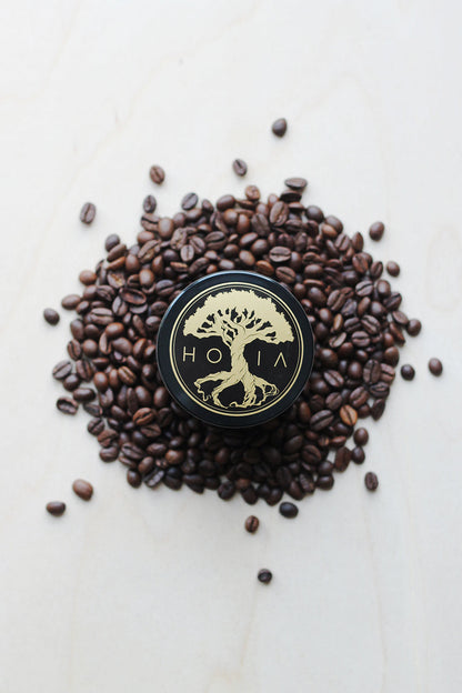 A round black container with a tree on top of coffee beans, part of the Body Scrub Coffee & Peppermint collection from Men In Style.