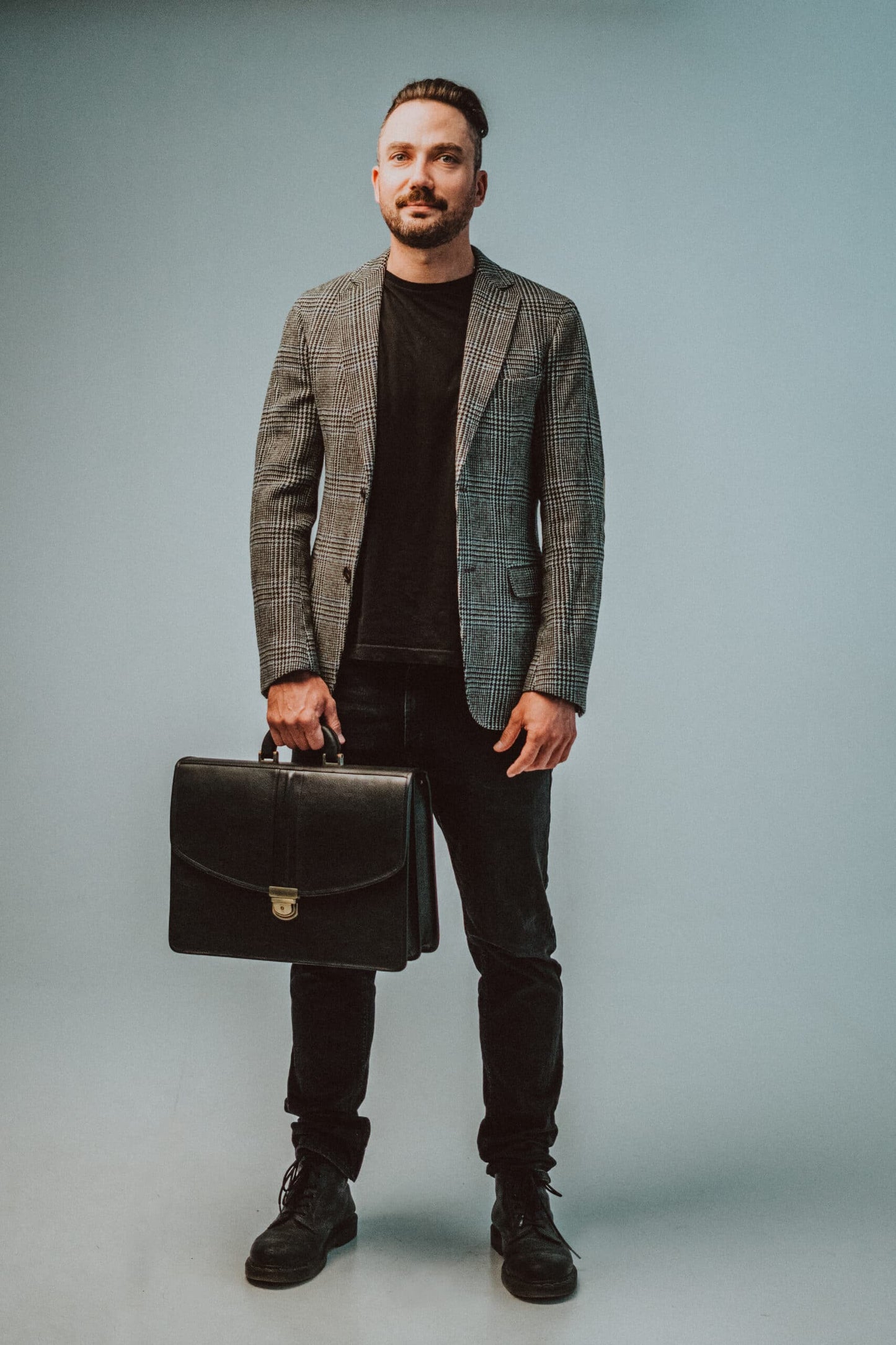 A professional man holding a Genuine Leather Briefcase - 2 Compartments - Black, showcasing timeless style and practical functionality for the modern gentleman.