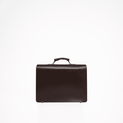 A black leather briefcase with a handle, featuring a main compartment for a laptop and a smaller pocket for a notebook or iPad. Two separate smaller pockets are located on the front of the bag. Comes with an adjustable leather shoulder strap. Crafted with durable, vegetable-tanned leather. Designed and produced in Europe with meticulous craftsmanship. Dimensions: 40.5 cm x 32 cm x 15 cm.