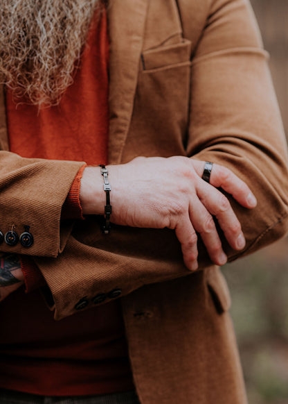 A man wearing the Cody bracelet, a sleek black ceramic accessory with a stainless steel clasp. Embrace timeless style with this lightweight and adjustable bracelet for him from Men In Style.