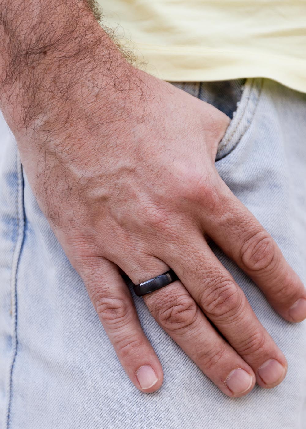 A close-up of a man's hand wearing the Men's ring Liuw, a lightweight and durable ceramic ring for the discerning gentleman.