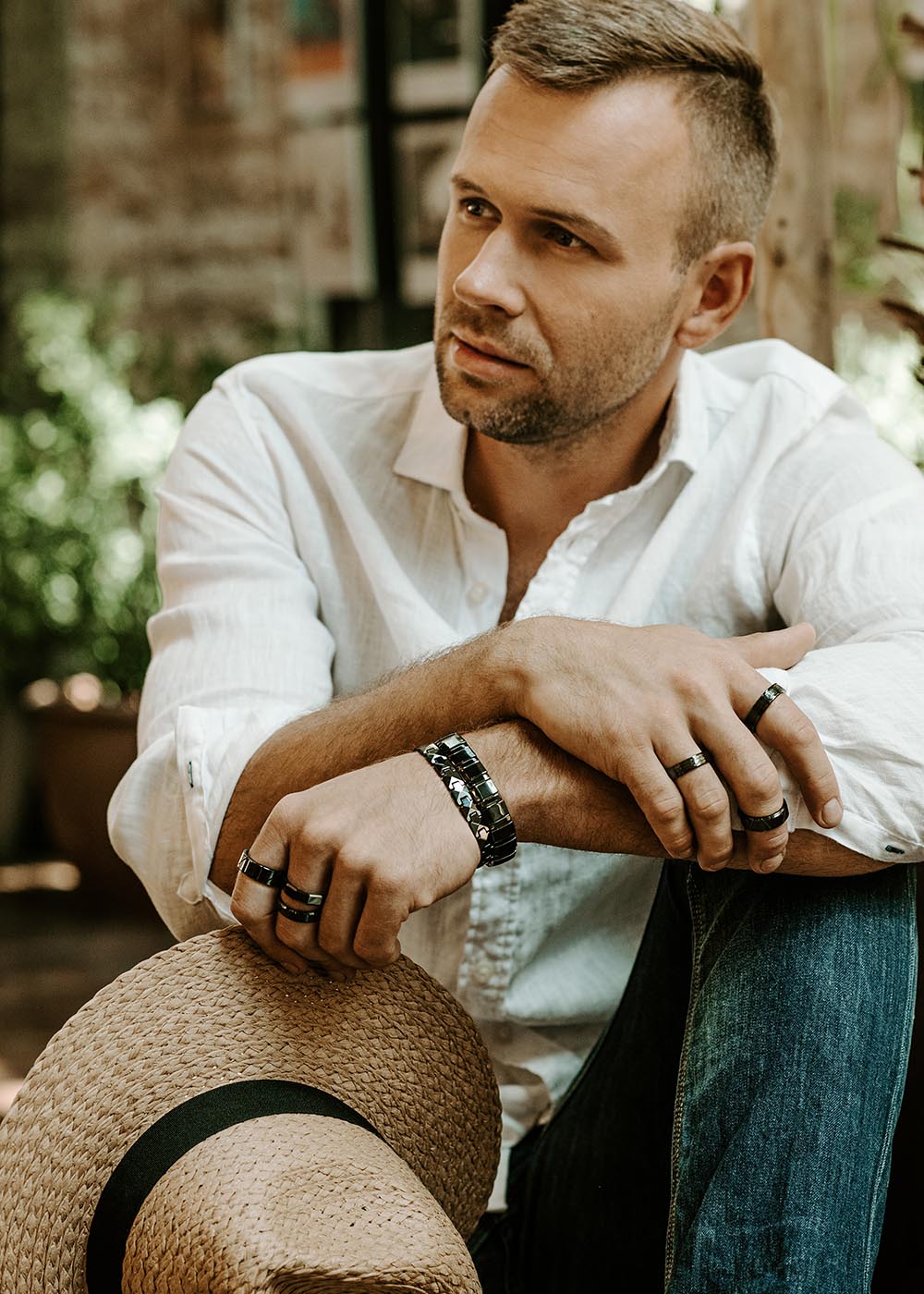 A man sitting with crossed hands wearing the Men's ring Rajona made of black high-quality ceramics from Men In Style.