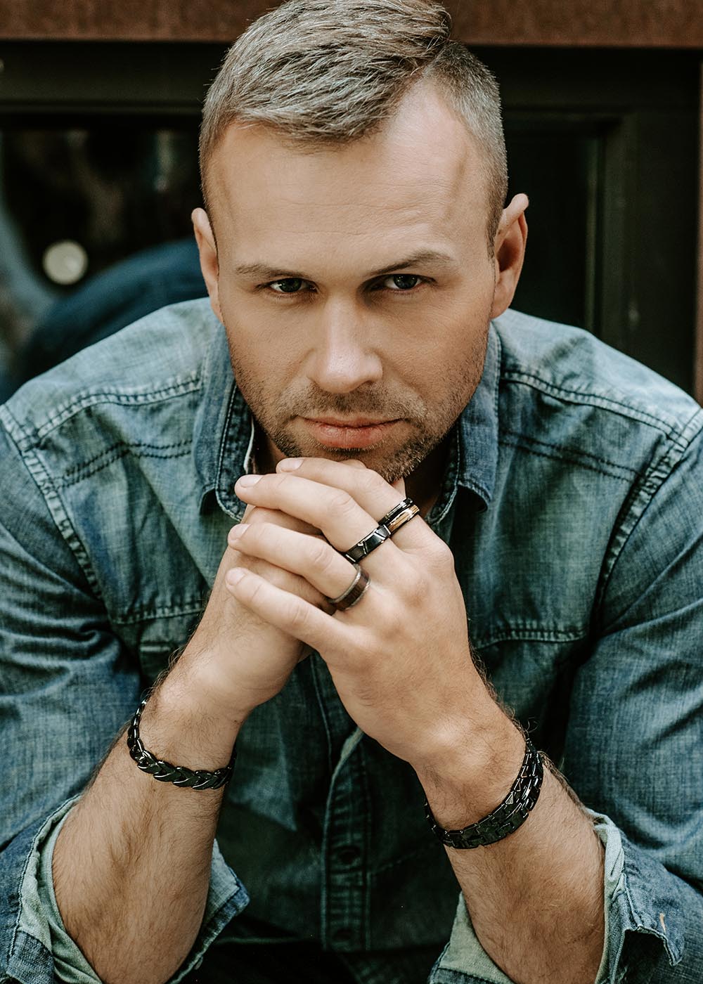 A close-up of a man's hands with rings on their fingers, wearing Men's ring Tau made of high-quality ceramics. Lightweight yet sturdy, this modern design embodies contemporary elegance for the discerning gentleman.