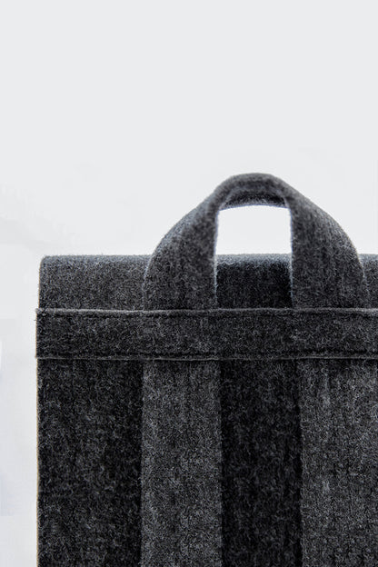 Backpack - Black: A close-up of a practical and stylish bag. Features laptop pocket, minimalist design, lightweight and spacious. Eco-friendly and weatherproof.