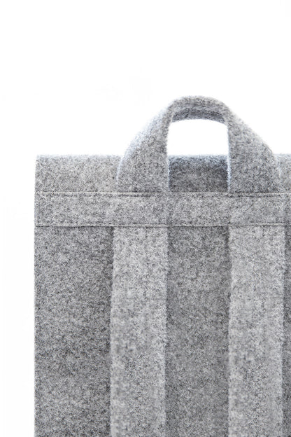 Backpack - Grey, close-up of a stylish bag with a laptop pocket, minimalist design, lightweight and spacious, adjustable straps, durable felt construction, eco-friendly and weatherproof.