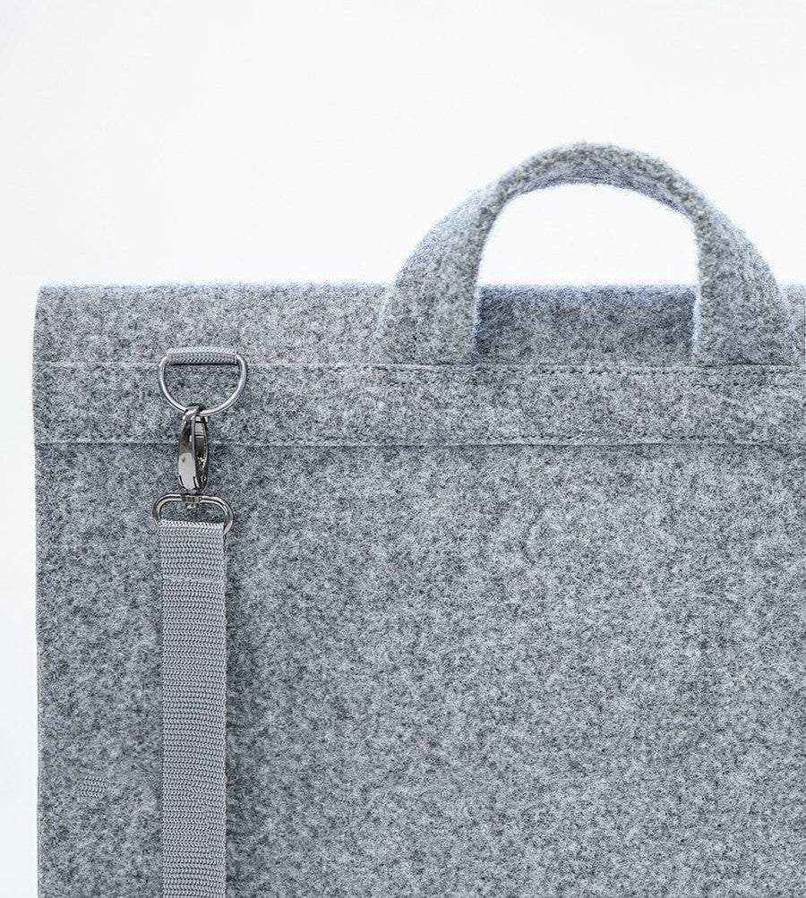 A close-up of a grey briefcase for a 15" laptop, crafted with sleek design and functionality. Lightweight, weatherproof, and made from recycled PET felt. Perfect for the modern professional.