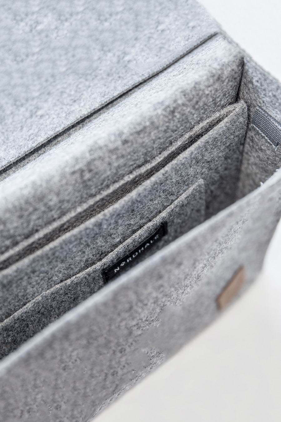 A close-up of a grey felt briefcase with a separate sleeve for up to a 15" laptop. Sleek and minimalistic design for the modern professional.