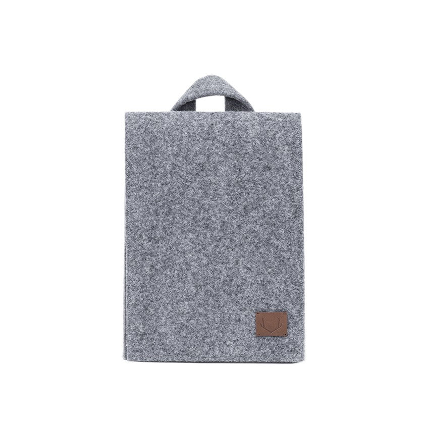 Mini Backpack - Grey: A compact, functional bag with a sleek grey design and a brown leather patch. Spacious enough for essentials and a small laptop.