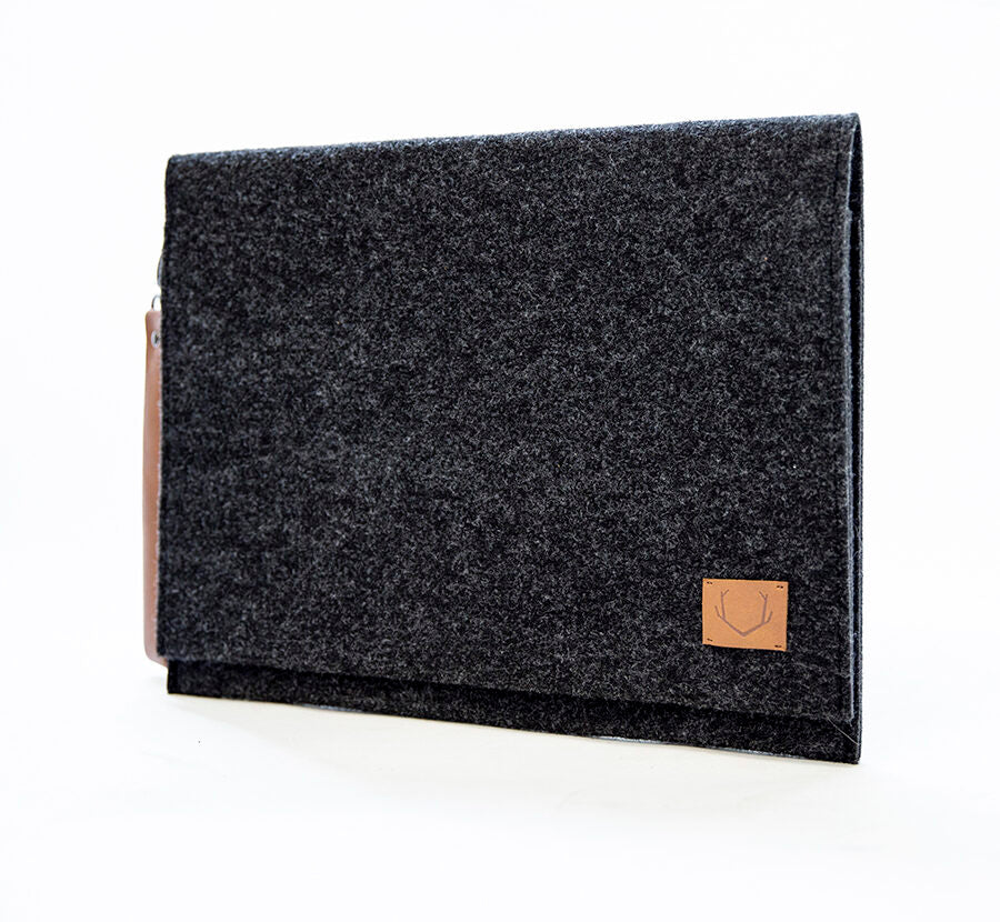 A close-up of the Slim Document Case or Laptop Bag - 13" Black. A black rectangular case with a brown patch, perfect for carrying documents or a laptop. Unisex design, weatherproof, and made from recycled PET felt. Handcrafted in Europe for quality.