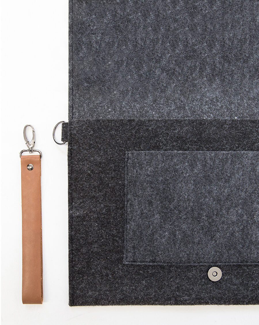 A close-up of the Slim Document Case or Laptop Bag - 13" Black. Sleek and practical, with a removable wristband and weatherproof construction. Handcrafted in Europe from recycled PET felt. Lightweight and eco-friendly. Elevate your professional look with this sophisticated design.