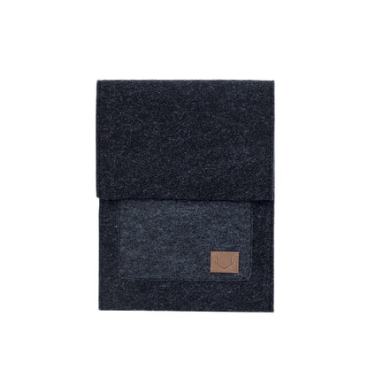 A slim fit envelope sleeve for Macbook Air & Pro - 13" Black, featuring a black rectangular object with a brown patch and a close-up of a black and grey blanket. Crafted with simplicity and functionality in mind, this sleeve offers a sleek style while keeping your laptop and accessories safe and secure.