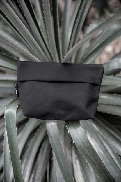 Toiletry bag on a plant, water-resistant with YKK® zippers. Practical and lightweight design for travel enthusiasts. Available in two sizes.