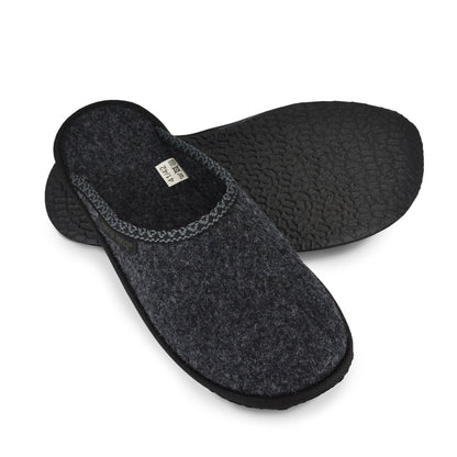 A pair of black Natural Felt Slippers, crafted in Europe from high-quality materials. Experience warmth, comfort, and sustainability with these easy-to-slip-on slippers. Designed for authenticity and durability, they are perfect for keeping your toes warm without making them sweat.