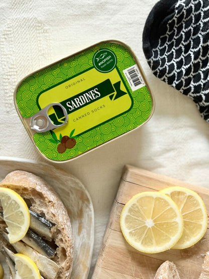 French Sardine Socks in a Can - size 35-46, depicted alongside lemon slices, creatively packaged to resemble a can of sardines, offering a unique accessory experience.