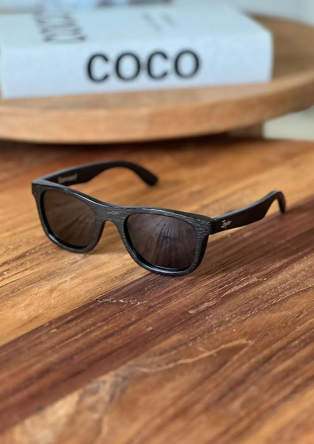 A pair of "Obsidian Shade" wayfarer sunglasses by Eyewood, handcrafted from black bamboo wood. Polarized lenses provide UV protection and enhance clarity. Lightweight and comfortable design perfect for sunny days.